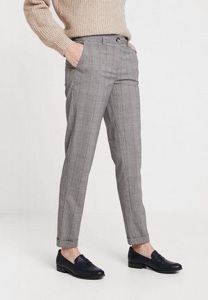 Pantalons à carreaux grisonnants avec une coupe ajustée, poches avant et manches retroussées, associés à des mocassins navy. Mélange de laine avec une texture lisse.