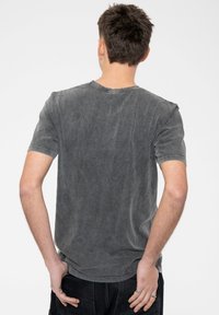 Gray cotton t-shirt with a round neck, short sleeves, and subtle texture. Features a relaxed fit and faded finish.
