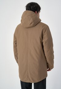 Braune, isolierte Parka mit hohem Kragen und verstellbarem Kapuze; glatte, matte Oberfläche; reicht bis zur Mitte des Oberschenkels; mit Seitentaschen.