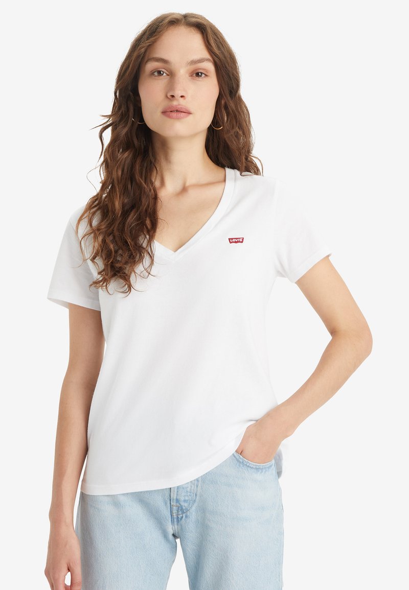 Bijela pamučna majica s V-izrezom, kratkim rukavima i malim crvenim Levi's logotipom na lijevoj strani prsiju. Glatka tekstura i standardni kroj.