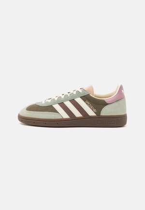 Zapatilla Adidas de corte bajo en pana marrón y verde menta con rayas blancas, etiqueta rosa en el talón y suela marrón texturizada.