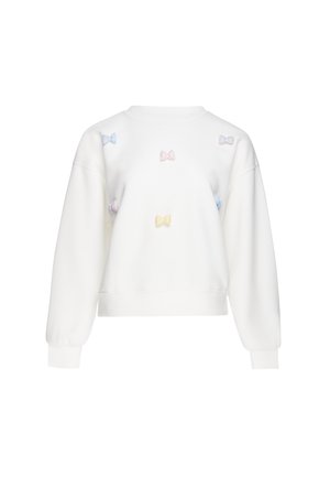 Witte trui met lange mouwen met pastelkleurige kleine strikapplicaties verspreid over de voorkant en mouwen.