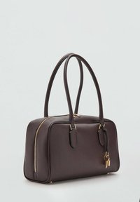 Hnedá kožená kabelka s obdĺžnikovým tvarom, zlatým zipsom a ozdobou v podobe kľúča. Má dvojité rukoväte a hladký povrch.