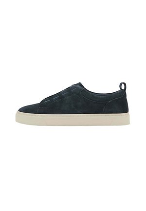 Niskie czarne zamszowe sneakersy z beżową podeszwą, bezsznurowane, z pętelką na pięcie ułatwiającą zakładanie.