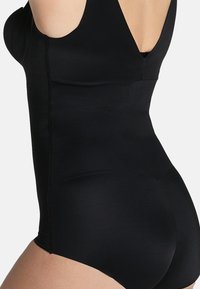 Zwarte bodysuit van een gladde, rekbare stof, met een diepe U-vormige rug en brede banden. Het heeft een getailleerde pasvorm die de taille en heupen accentueert.