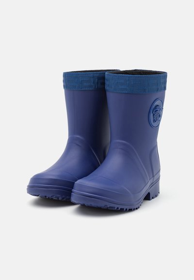 Bottes de pluie en caoutchouc bleu marine avec des poignets en tissu bleu foncé texturé, arborant un emblème circulaire de lion et une semelle robuste pour une bonne adhérence.