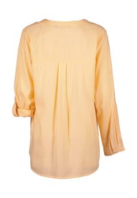 Camicia gialla a maniche lunghe con piega sul retro, scollo rotondo e polsini arrotolati. Realizzata in tessuto leggero con una texture liscia.