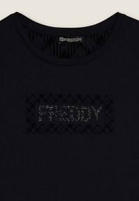 Camiseta negra de cuello redondo; presenta un logo decorativo "FREDDY" en tachuelas plateadas sobre un fondo texturizado. Tejido suave.