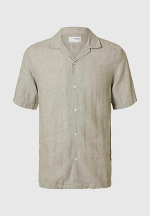Chemise en lin beige clair à manches courtes avec un col en V, cinq boutons sur le devant, et un tissu texturé et respirant.