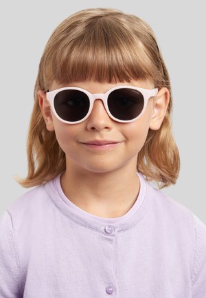 Bambino piccolo con capelli castano chiaro che indossa occhiali da sole rotondi con montatura bianca e una camicia lilla chiaro abbottonata, sorridendo leggermente.