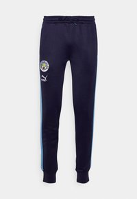 Marineblaue Jogginghose mit einem Kordelzugbund, hellblauen Seitenstreifen, Manchester City-Logo und Puma-Branding am unteren Bein.