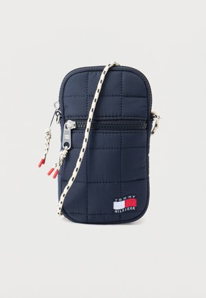 Granatowa pikowana torba na ramię z przednią kieszenią zapinaną na zamek, czarno-biały wzorzysty pasek sznurowy oraz naszywka z logo Tommy Hilfiger.