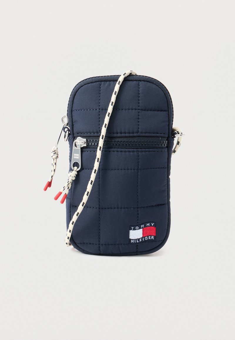 Μπλε ναυτικό καπιτονέ τσαντάκι χιαστί με μπροστινή τσέπη με φερμουάρ, λουράκι με άσπρο και μαύρο μοτίβο κορδονιού και ετικέτα με το λογότυπο Tommy Hilfiger.