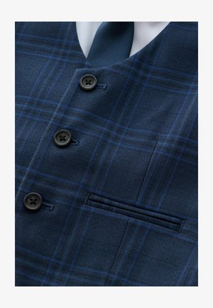 Gilet à carreaux bleu marine avec des boutons noirs, une poche poitrine et une texture qui évoque un tissu en laine. Accessoirisé d'une cravate bleu foncé.