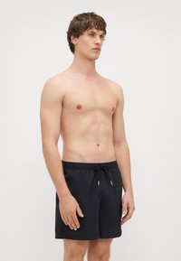 Czarne kąpielówki wykonane z lekkiego materiału. Posiadają elastyczny pasek w talii z systemem sznurka oraz luźny krój. Gładka tekstura.