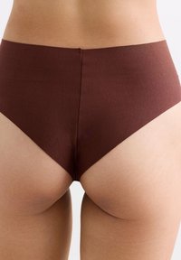 Bruine high-waisted slip gemaakt van zacht, rekbaar materiaal. Beschikt over een gladde textuur en minimale naden voor comfort, met een mid-rise snit.