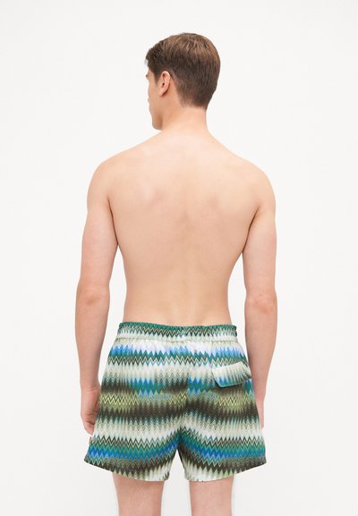 Férfi fürdőshorts színes zigzag mintával, zöld, kék és fehér színekben. Rugalmas derékpánt hátsó zsebbel. Könnyű anyag.