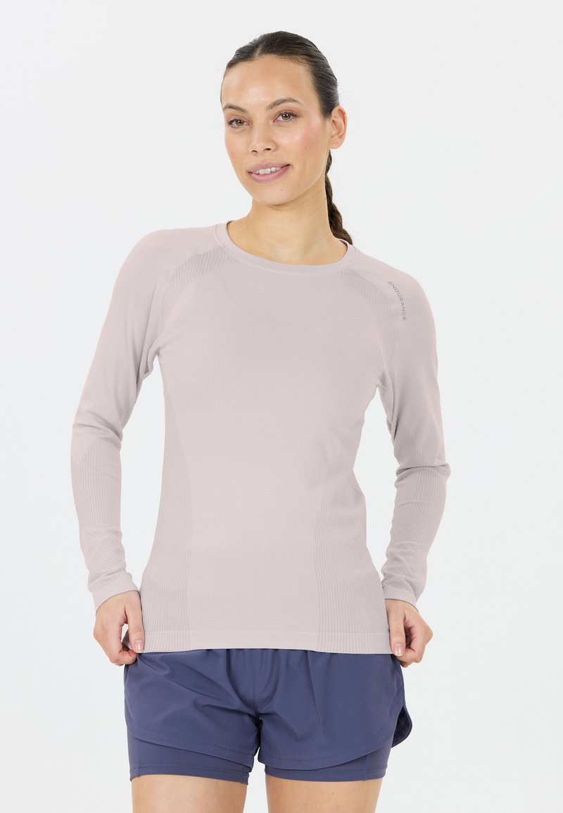 Hellblaues Langarm-Sportoberteil mit enganliegendem Schnitt und geripptem Muster, kombiniert mit marineblauen Shorts.