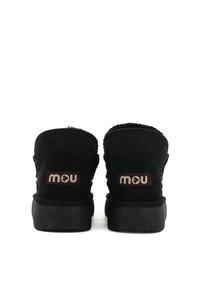 Zwarte suede enkellaarsjes met een ronde vorm, voorzien van gevlochten accenten en een logopatch op de hak. Rubberen zool voor grip.