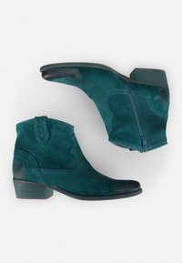 Türkisfarbene Wildleder-Stiefeletten mit abgerundetem Zehenbereich, seitlichem Reißverschluss, dekorativer Naht und niedrigem, gestapeltem Absatz. Schmetterlingslogo an der Außenseite.