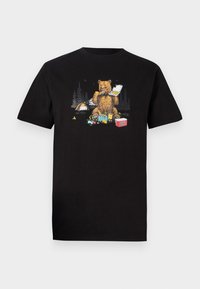 Zwarte katoenen t-shirt met een graphic van een beer die een voedselcontainer vasthoudt, omringd door campingelementen zoals een tent en voorwerpen.