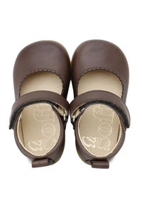Zapatos infantiles de cuero marrón con punteras redondeadas, bordes con ondas y correas ajustables. Plantillas texturizadas con marca impresa en el interior.