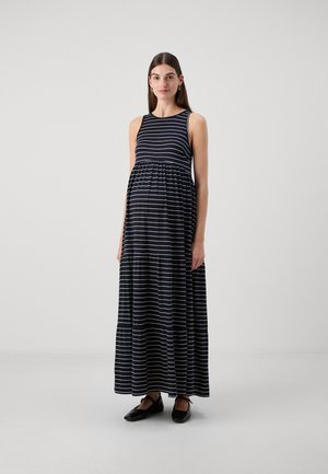 Abito maxi con righe orizzontali blu e bianche, design senza maniche, vita arricciata, tessuto fluido e vestibilità comoda. Scarpe nere senza tacco.