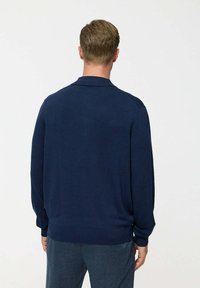 Pulover tricotat de culoare bleu marin, cu guler. Prezintă mâneci lungi și manșete elasticizate, realizat dintr-un material moale și texturat. Vedere din spate.