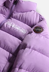 Giacca puffer viola con sezioni trapuntate, zipper frontale e il logo "Napapijri" stampato in bianco. Presenta una toppa circolare sulla manica.