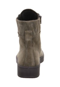 Stivaletto alla caviglia in camoscio verde oliva con punta arrotondata, suola nera piatta, dettagli di cuciture diagonali e una zip laterale per facilitare la calzata.