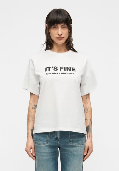 Weißes Baumwoll-T-Shirt mit kurzen Ärmeln, auf dem in fetter, auffälliger Schrift schwarzer Text steht: "IT'S FINE" und "just stick a filter on it".