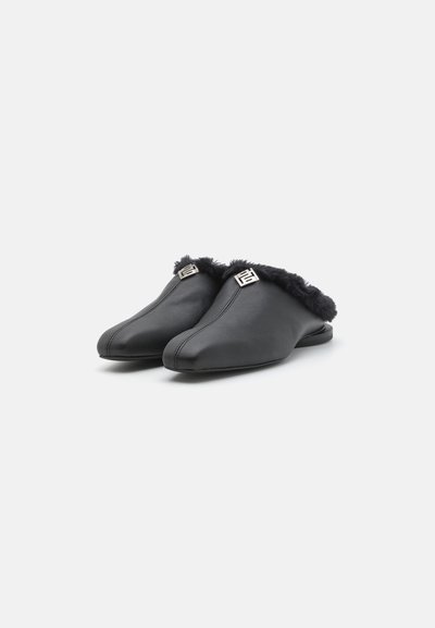 Chaussons en cuir noir avec un trim en fourrure noire moelleux, un design à bout pointu et un détail en métal argenté sur le dessus, offrant une apparence élégante.
