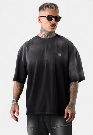 Schwarzes, oversized T-Shirt aus Baumwolle mit einem verwaschenen Design, Rundhalsausschnitt, kurzen Ärmeln und einem kleinen Logo auf der linken Brustseite.