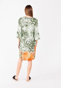 Das floral gemusterte Kleid verfügt über einen grünen und orangefarbenen Farbverlauf, hat eine lockere Passform und Glockenärmel. Hergestellt aus leichtem Stoff, knielanges Design.