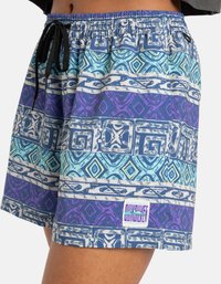 Blå og lilla mønstrede badeshorts med snøring i taljen, med geometriske design og et logo-patch på kanten.