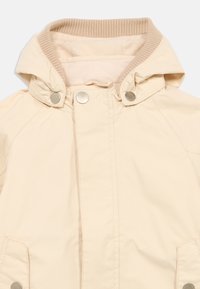 Μπεζ ελαφρύ μπουφάν με κουκούλα· διαθέτει ριμπ κολάρο, κουμπιά με κλιπ και πλαϊνές τσέπες. Το υλικό φαίνεται λείο, υφή μαλακή.