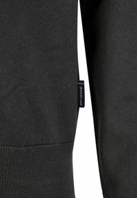 Schwarzer Sweatshirt aus strukturiertem Stoff mit gerippten Bündchen und Saum. Enthält ein kleines Etikett mit "HECHTER" an der Seite.