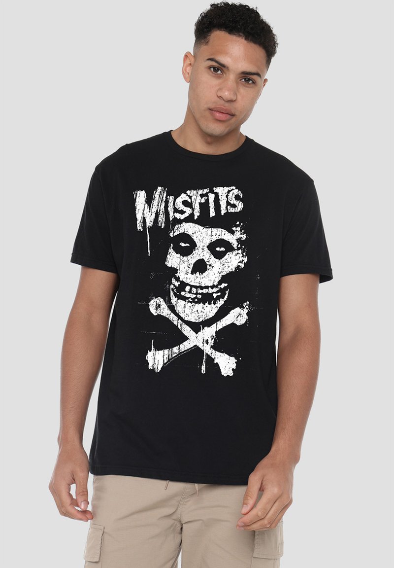 Black cotton t-shirt featuring a prominent white skull and crossbones graphic, with the word "Misfits" above in a distressed style.