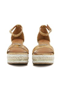 Sandali con zeppa in sughero color tan, dotati di cinturini alla caviglia, con suole in juta intrecciata e dettagli in oro sui cinturini. Soletta in pelle liscia.