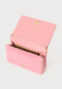 Borsa rosa con una texture in peluche sul fronte e retro in pelle liscia. Presenta una chiusura a scatto dorata e una tracolla a catena removibile.