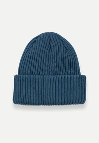 Modrá pletená čiapka s rebrovanou štruktúrou a preloženým okrajom. Materiál pôsobí mäkko a elasticky, vhodný na bežné nosenie.