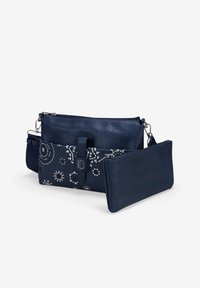 Bolso cruzado de cuero marino con bordado floral, compartimentos con cremallera y una correa desmontable. Textura suave con acentos metálicos.