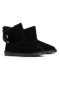 Botas de tobillo de ante negro con un acabado texturizado, que cuentan con un puño plegable, elementos decorativos y suelas de goma.