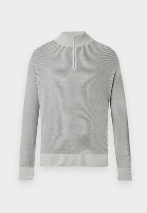 Grå ribbad stickad tröja med hög krage och halvdragkedja. Långa ärmar och ett åtsittande midjeband, med strukturerade detaljer genom hela tröjan.