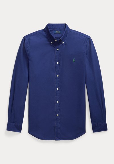 Navy blue long-sleeve button-up shirt made of cotton. Features a pointed collar and small green embroidered logo on the left chest.