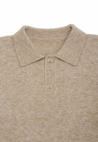 Beige Strick-Polohemd mit weicher Textur, Kragen und drei hellen Knöpfen an der Knopfleiste.