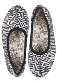Ballet flats met een zwart-wit geometrisch patroon, voorzien van een zachte stoffen bovenkant en een zwarte rand rond de opening.