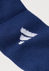 Κάλτσα πλεκτή σε ναυτικό μπλε με υφή στην επάνω πλευρά και λευκό τριγωνικό μοτίβο υφασμένο στο σχέδιο.