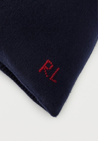 Πλεκτό ύφασμα σε ναυτικό μπλε με κόκκινα κεντημένα αρχικά "RL" σε διπλωμένη γωνία, πάνω σε λευκό φόντο.