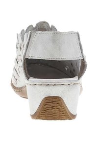 Sandales blanches en daim avec un talon tissé, un design à dos ouvert et une semelle texturée. Présente un accent tressé à l'avant.